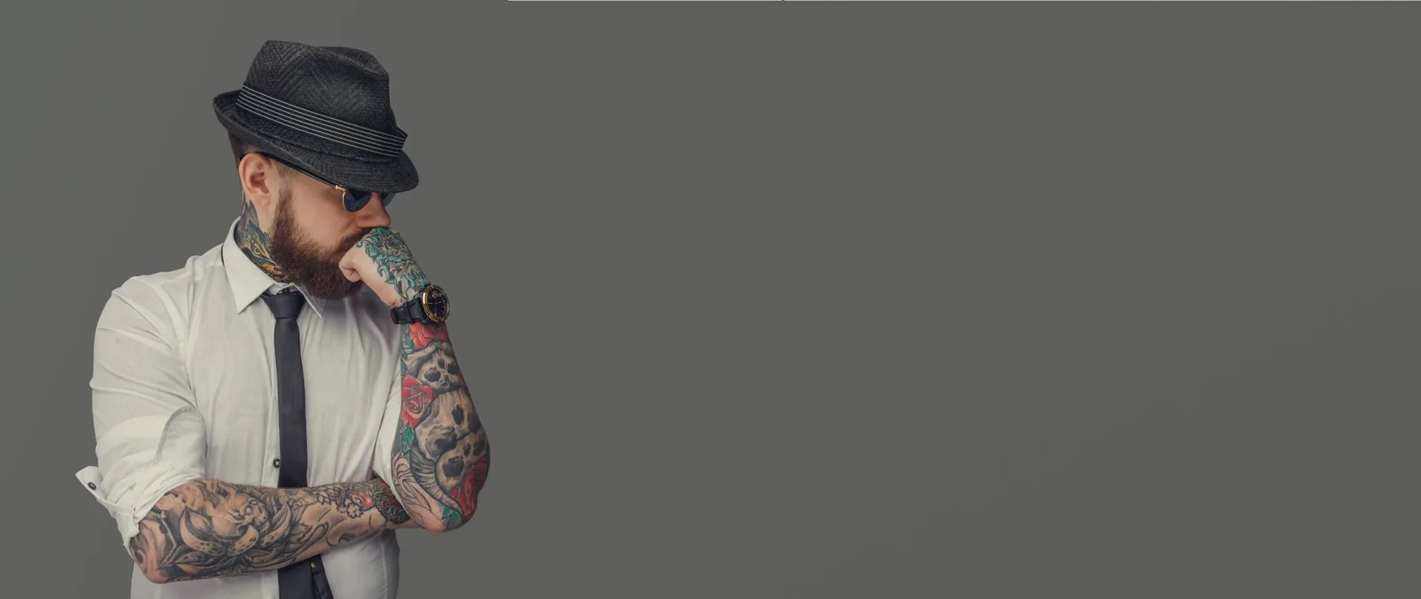 Mężczyzna z tatuażami w garniturze — klimat studia Terra Tattoo